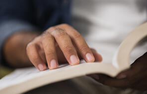 Close up of male hand open book and reading.