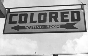 Sign at bus station reads "Colored Waiting Room."