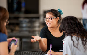 A female student engages in discussion. 