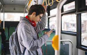 Image of boy looking at phone on bus.