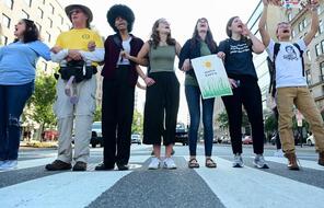 Demonstrators stand in a crosswalk to protest climate change.