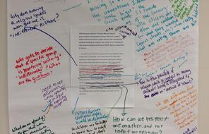 A text quotation taped on a large piece of paper with student feedback written in markers.
