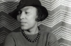Author Zora Neale Hurston wearing a hat with her head turned to her right.