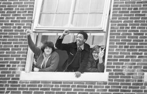 Youngsters signal from a window in Hyde Park High School on Monday, Sept. 23, 1974 in Boston a generally peaceful day in the city's attempts at school desegregation