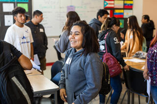 A students talks with other students in a classroom