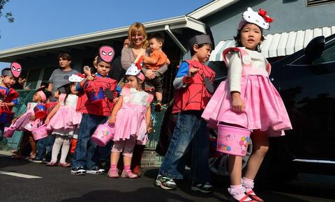 Schoolchildren dressed in Halloween costumes, Spiderman for boys and Hello Kitty for girls.