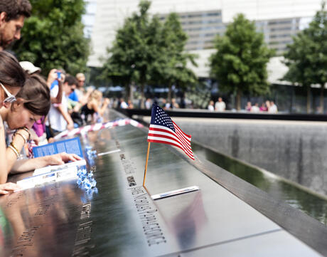 Tourists surround a USA flag at the World Trade Center.