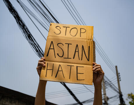 Man holding stop Asian hate sign.