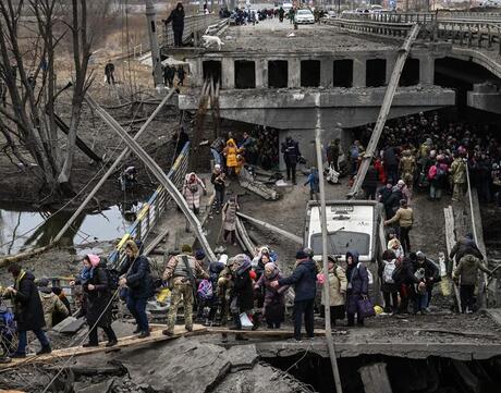 Ukrainian Refugees crossing a fallen bridge.
