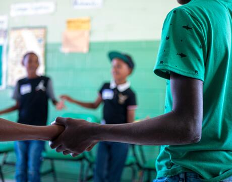 Children holding hands in classroom